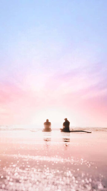 Two people enjoying a tranquil sunset on the beach during summer vacation