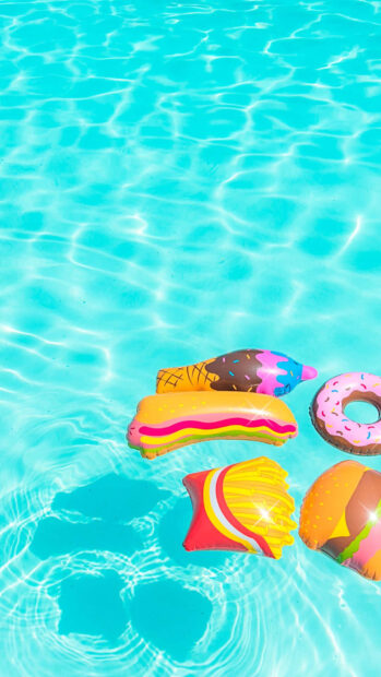 Colorful summer inflatables floating on bright clear water in a pool