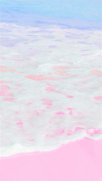 Soft pastel summer waves gently flowing over a pink sandy shore