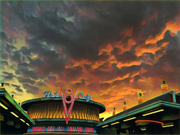 Radiator Springs at dusk with vibrant colorful sky and Flo's V8 Cafe neon sign in view