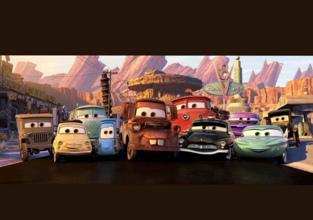 Radiator Springs characters smiling together on the town road at sunset