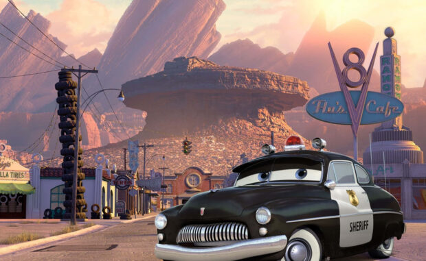 Radiator Springs featuring the sheriff car in a small town setting with rocky mountains in the background