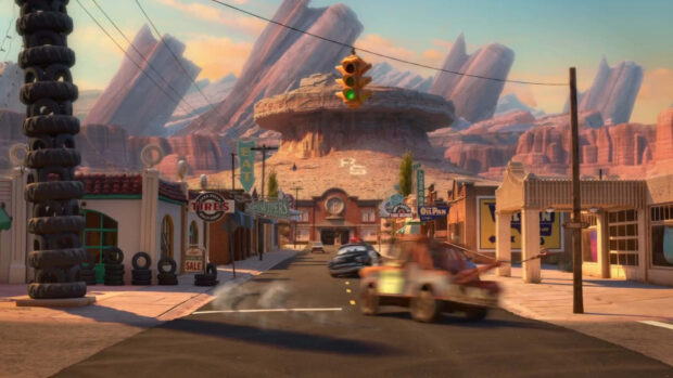 A view of Radiator Springs with classic buildings and cars on the main street under a green traffic light