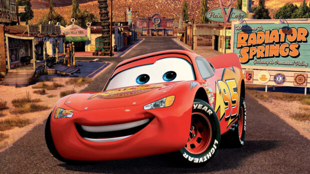Lightning McQueen is smiling on the road in Radiator Springs townscape