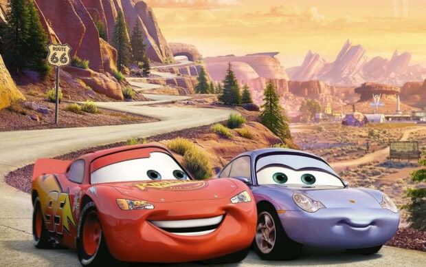 Radiator Springs characters smiling on a winding road in scenic desert landscape