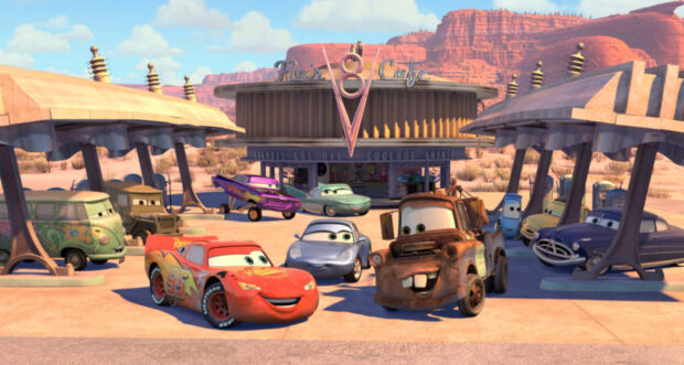 Radiator Springs shows a lively scene with colorful cars gathered near a vintage gas station in a desert setting