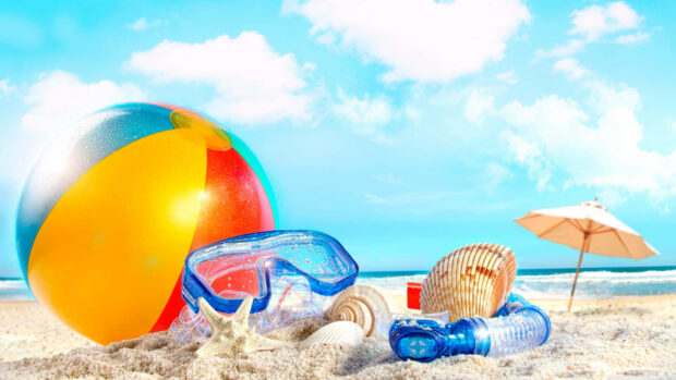 Colorful beach ball and snorkeling gear on sand at the beach during summer aesthetic