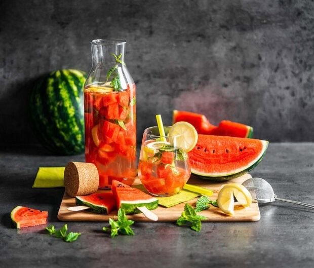 Refreshing watermelon drink with lemon and mint on a wooden board