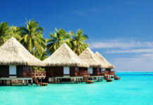 Tropical huts over ocean on summer vacation