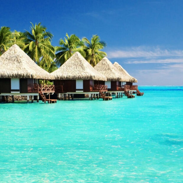 Tropical huts over ocean on summer vacation