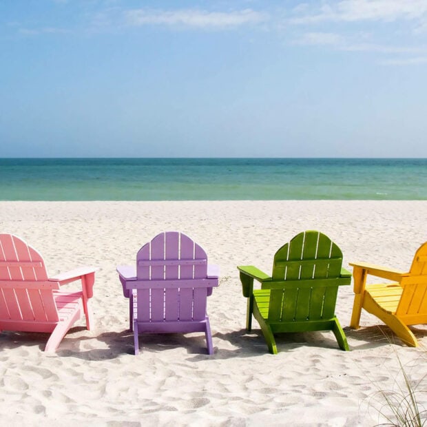 Colorful chairs on the beach with sand and ocean in summer scenery