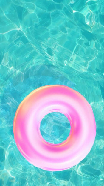 Pink inflatable ring floating on clear blue water with summer vibes