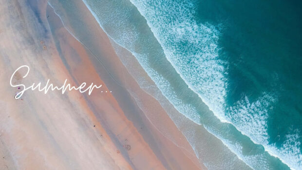 Aerial view of a sandy beach with ocean waves and summer atmosphere