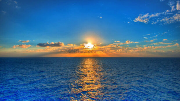 Ocean sunset with golden sunlight reflecting over the calm sea surface