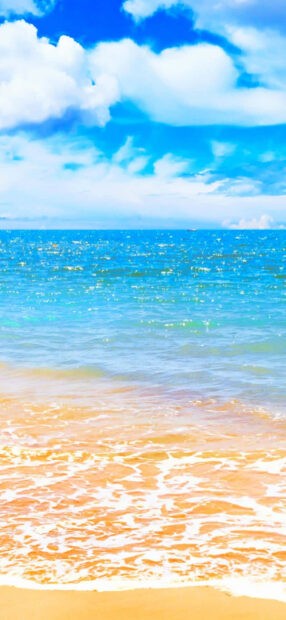 A peaceful beach with golden sand and blue ocean under a bright sky in summertime