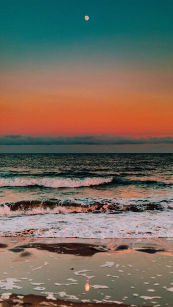 A serene ocean sunset with gentle waves and the moon reflecting on the water