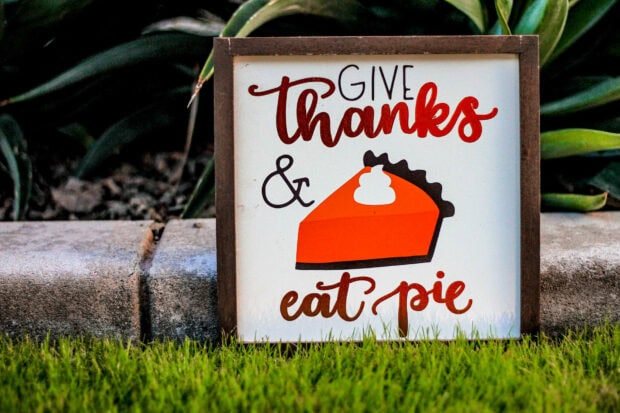 Framed wooden sign displays the phrase 