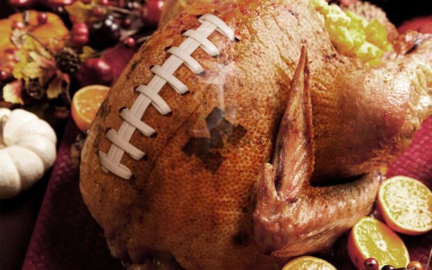 Roasted turkey features football lacing and a team logo, displayed with festive autumn garnishes