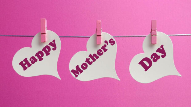 Three white heart cards hang from a string, displaying 