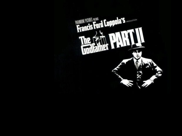 A man in a fedora and suit stands with hands on hips, displaying the iconic movie title against a deep black background