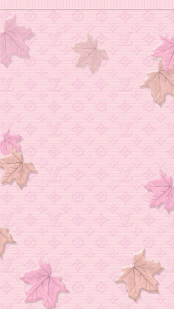 Pastel maple leaves scatter across a light pink background subtly embossed with a luxury brand pattern