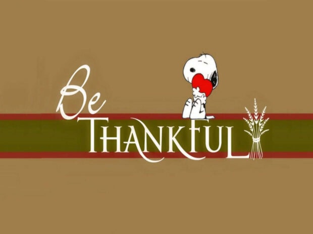 Snoopy character embraces a red heart beside 
