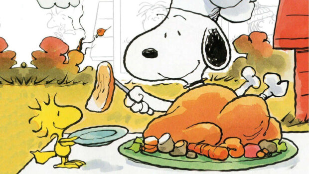 Snoopy, wearing a chef hat, carves a roasted turkey as Woodstock holds a plate