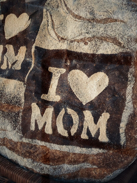 A rustic sourdough loaf displays a heartfelt message 