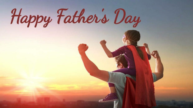 A man carries a young girl on his shoulders, both wearing superhero capes and raising their fists against a vibrant sunset sky