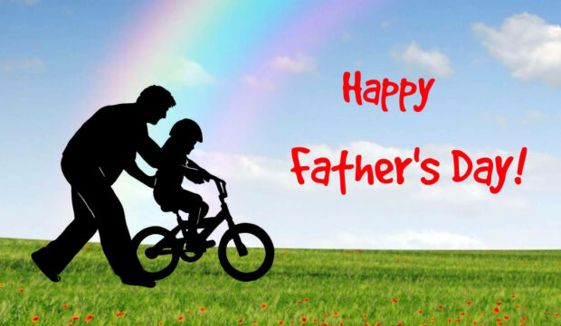 Adult silhouette guides child riding bicycle across vibrant green field under rainbow sky with 