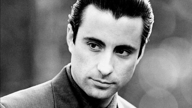 Vincent Corleone gazes contemplating in a black and white close-up, dressed in a sharp suit