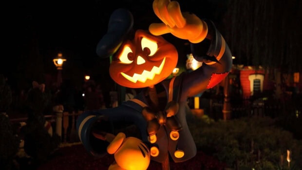 A vibrant 3D Halloween Wallpaper showing a glowing jack-o'-lantern scarecrow character at night