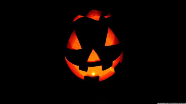 A minimalist 3D Halloween wallpaper featuring a single glowing jack-o'-lantern with a candle inside against a dark background