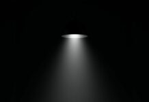 A black aesthetic wallpaper featuring a mysterious dark leather armchair under a single spotlight in a minimalist setting