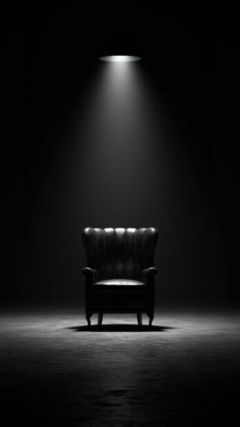 A black aesthetic wallpaper featuring a mysterious dark leather armchair under a single spotlight in a minimalist setting