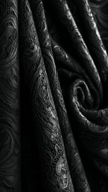 Black aesthetic wallpaper displaying intricately patterned dark fabric folds with elegant textures