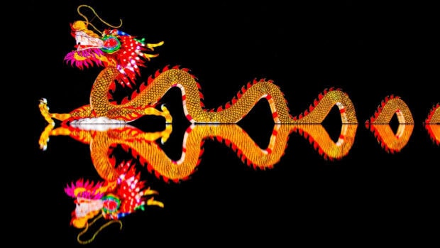 Chinese New Year Wallpaper showcasing an illuminated golden and red dragon with its reflection on a dark background