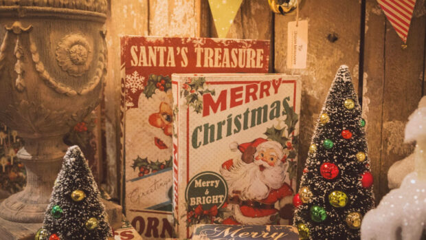 A nostalgic Christmas Collage Wallpaper showcasing vintage "Santa's Treasure" and "Merry Christmas" books surrounded by miniature decorated Christmas trees