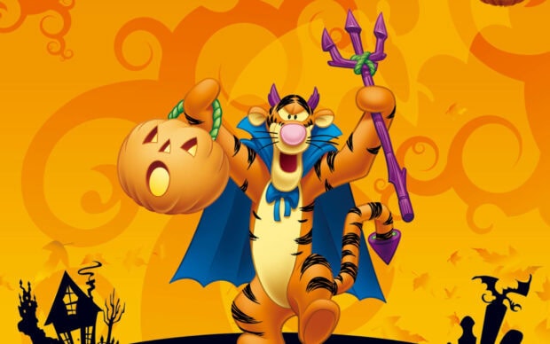 A Cute Disney Halloween Wallpaper depicting Tigger dressed as a devil holding a pumpkin and trident on an orange Halloween background
