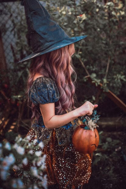 A cute Halloween witch with pink hair and a pumpkin bucket, included in a selection of cute Disney Halloween wallpaper