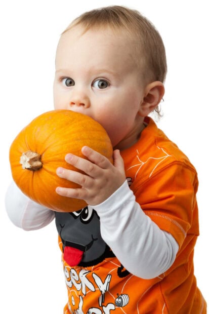 Cute Halloween Wallpaper featuring an adorable baby in an orange monster shirt holding a small pumpkin