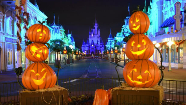 Disney Halloween wallpaper featuring Main Street U.S.A. decorated with glowing jack-o'-lanterns and Cinderella Castle under a dark night sky