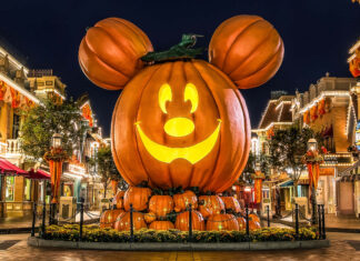 A stunning Disney Halloween wallpaper showing a giant Mickey Mouse pumpkin at night on a festive park street