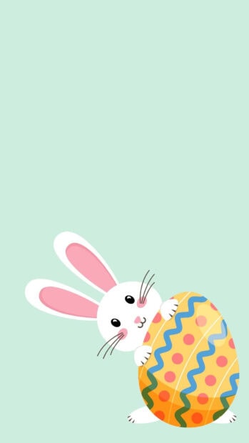 Cute cartoon Easter Bunny wallpaper featuring a white rabbit peeking with a colorful patterned egg on a light green background