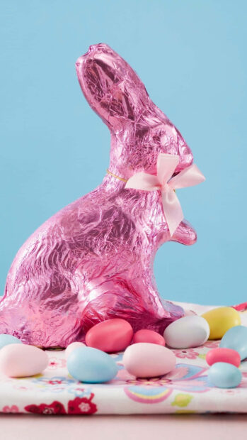Easter Bunny Wallpaper showcasing a shiny pink foil chocolate bunny surrounded by pastel Easter eggs