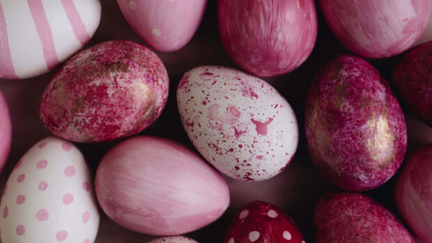 An overhead view of an Easter egg wallpaper showing a collection of pink, white, and gold speckled eggs