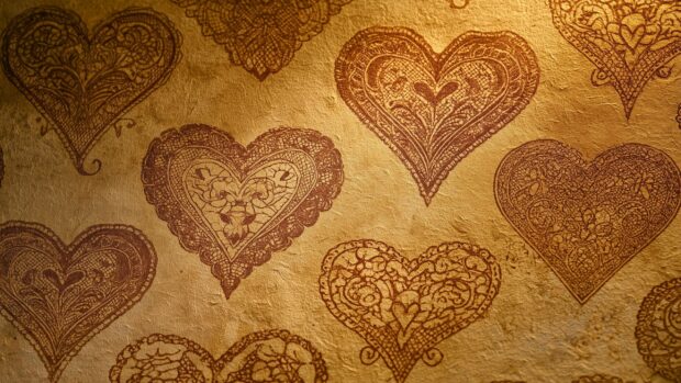 An elegant golden lace Heart Wallpaper featuring ornate heart patterns embossed on a rich, textured golden background