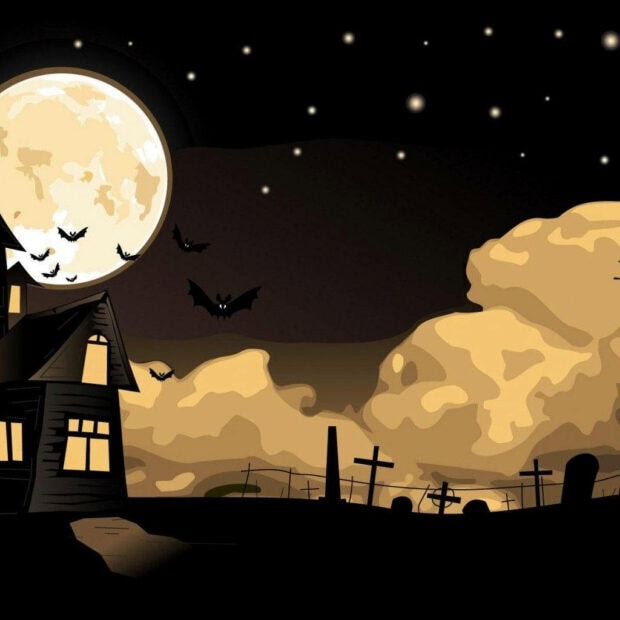 An eerie Halloween iPad wallpaper depicting a haunted house, bats flying near a full moon, and a graveyard