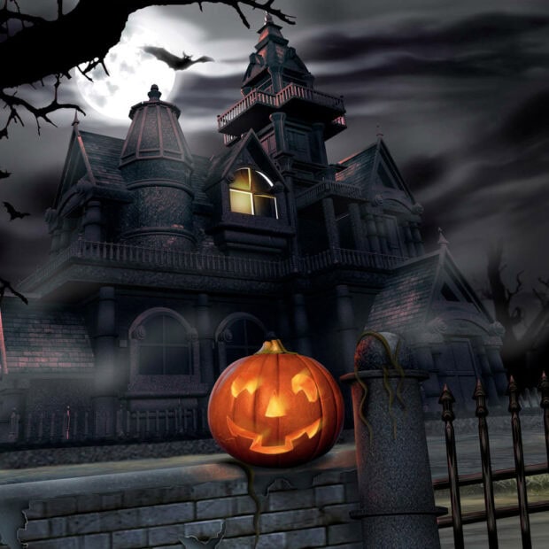 A spooky Halloween iPad wallpaper featuring a haunted house, full moon, and glowing jack-o'-lantern