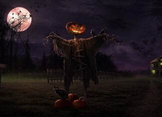 A dark Halloween Macbook Wallpaper showing a scarecrow with a glowing pumpkin head, a black cat, and a haunted house under a full moon